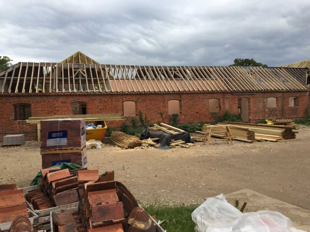 A barn conversion: a brick building with a roof and wooden beams.